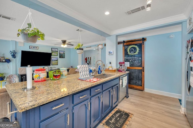 kitchen featuring blue cabinets, visible vents, ornamental molding, a sink, and a barn door