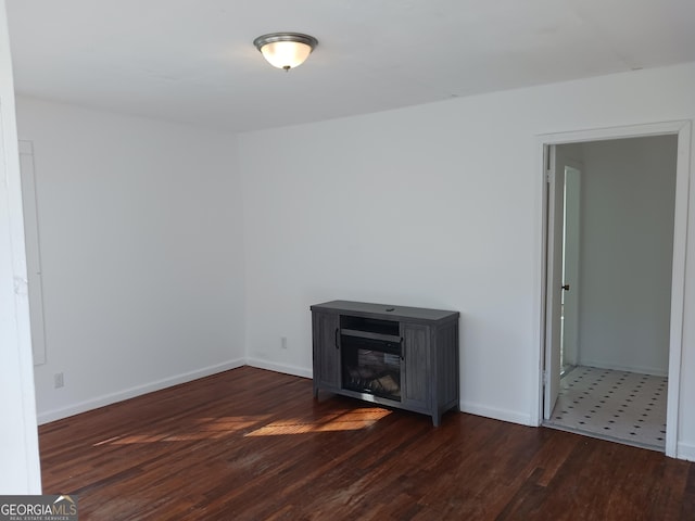 unfurnished room with dark wood-type flooring