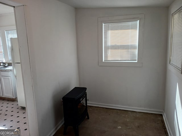 empty room featuring plenty of natural light, concrete floors, and sink