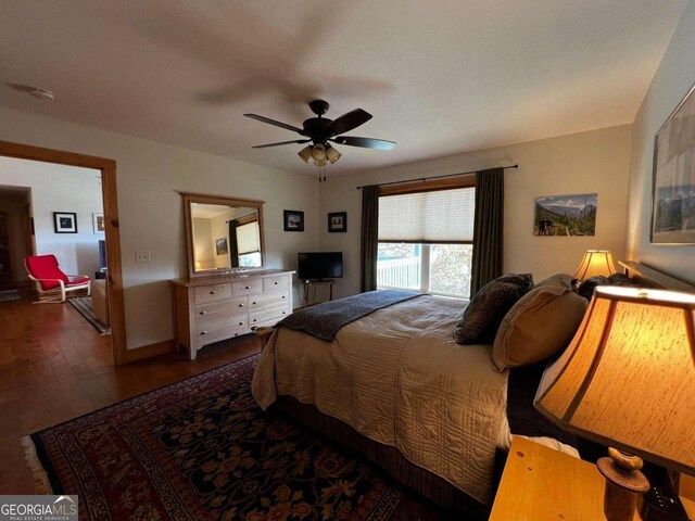 bedroom with ceiling fan and dark hardwood / wood-style flooring