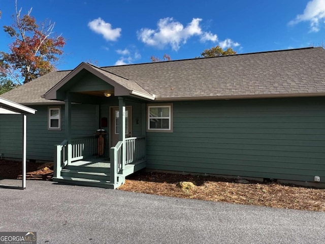 exterior space with a shingled roof, crawl space, and covered porch