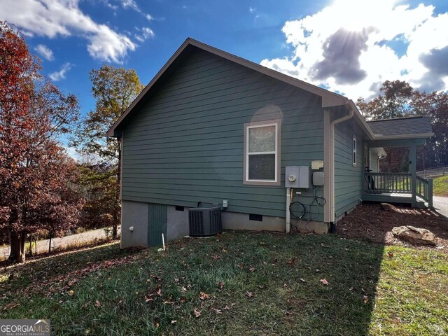 view of property exterior featuring central AC unit and a yard