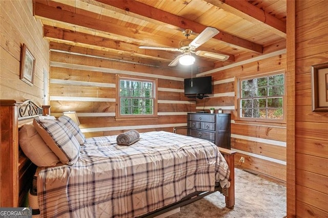 bedroom featuring wooden walls, multiple windows, and ceiling fan