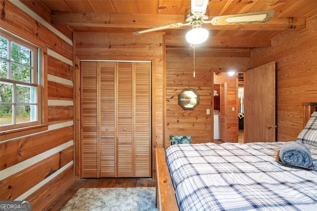 bedroom with hardwood / wood-style flooring, ceiling fan, beam ceiling, and a closet