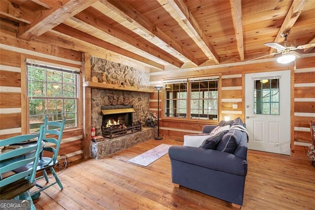 living room with a fireplace, beamed ceiling, wood-type flooring, and wood ceiling