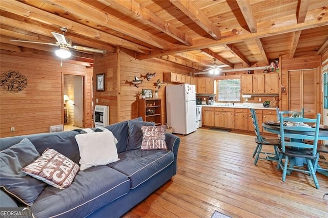 living room featuring beam ceiling, wooden walls, wood ceiling, ceiling fan, and light hardwood / wood-style flooring