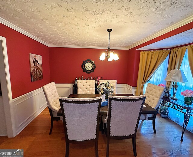 dining space with ornamental molding, a chandelier, a textured ceiling, and dark hardwood / wood-style floors