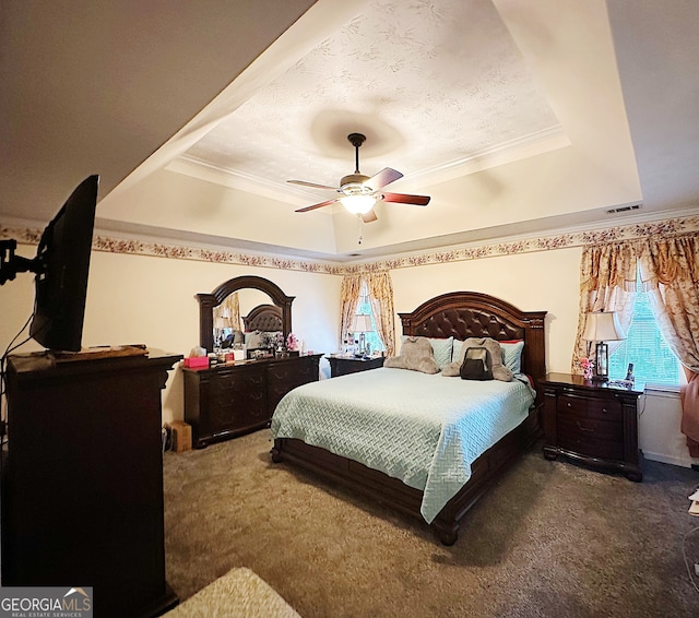 bedroom featuring crown molding, dark colored carpet, ceiling fan, and a raised ceiling