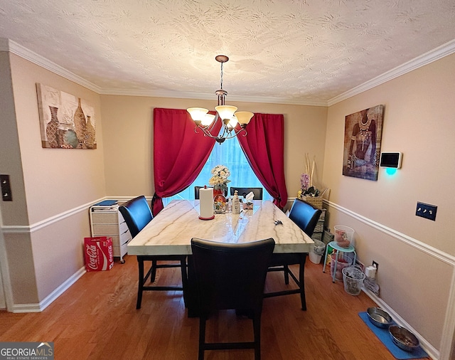 dining area with hardwood / wood-style floors, a chandelier, and ornamental molding