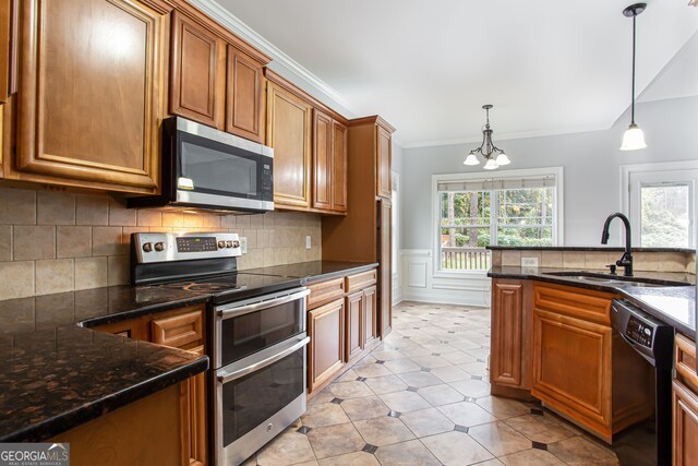 kitchen with stainless steel appliances, sink, dark stone countertops, hanging light fixtures, and a notable chandelier