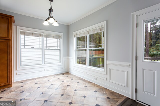 unfurnished dining area featuring a chandelier and crown molding