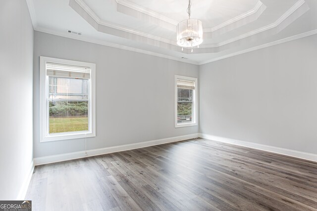 spare room featuring hardwood / wood-style flooring, a healthy amount of sunlight, and crown molding