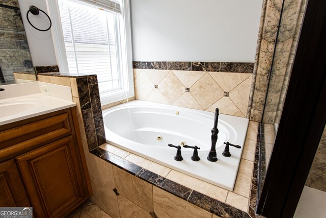 bathroom with vanity and tiled tub