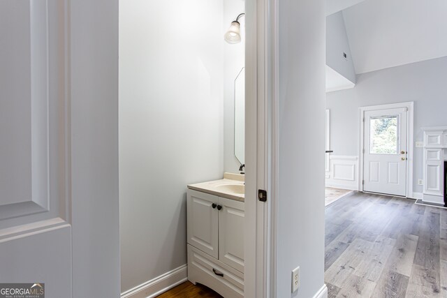 bathroom with vanity, lofted ceiling, and hardwood / wood-style flooring