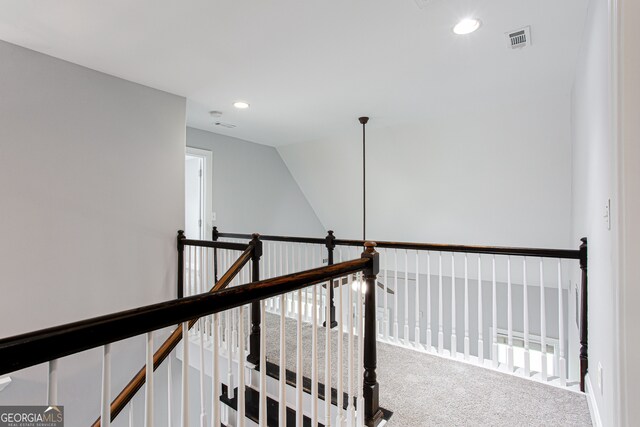 hall with carpet flooring and vaulted ceiling