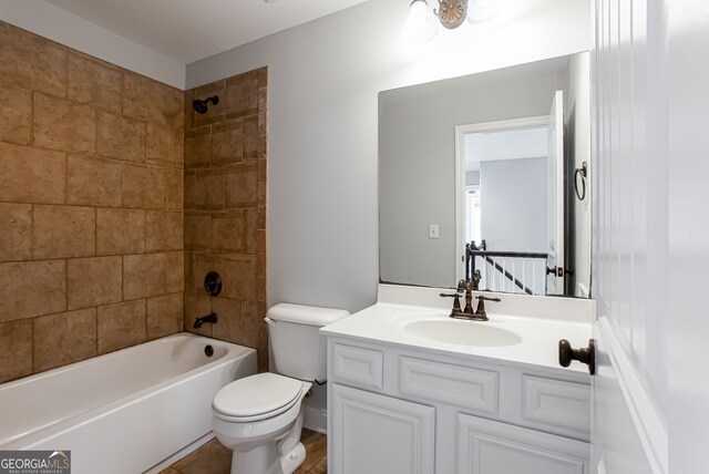 full bathroom with toilet, vanity, and tiled shower / bath