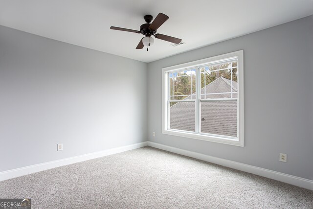 carpeted spare room featuring ceiling fan