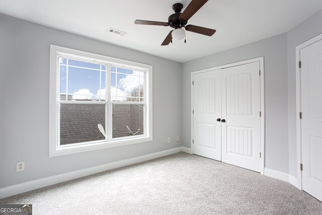 unfurnished bedroom with carpet, ceiling fan, and a closet