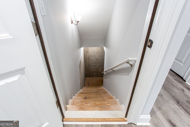 stairs featuring hardwood / wood-style floors