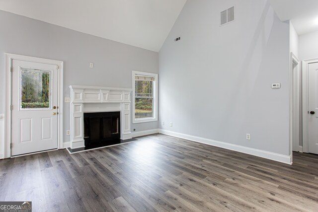 unfurnished living room featuring hardwood / wood-style floors and high vaulted ceiling