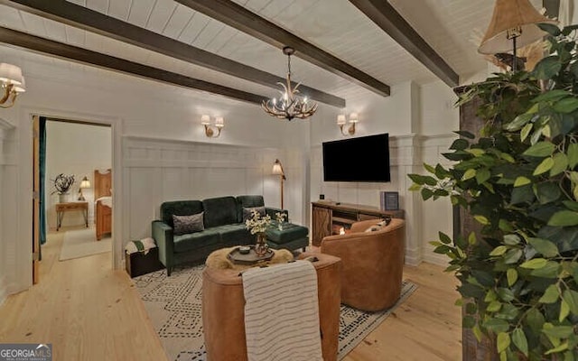 living room featuring light wood-type flooring, beamed ceiling, and a chandelier