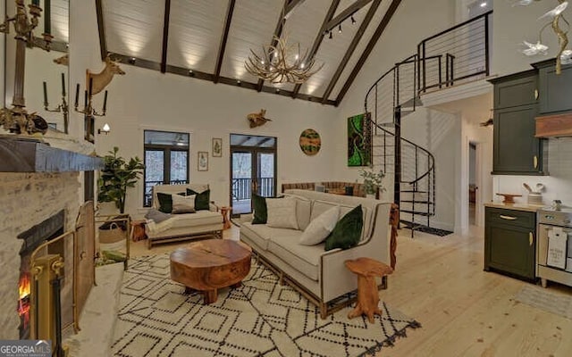 7670 Hiawassee Wilderness Trl, Hiawassee, GA 30546 - living room with high vaulted ceiling, a chandelier, a lit fireplace, beam ceiling, and light wood-style flooring