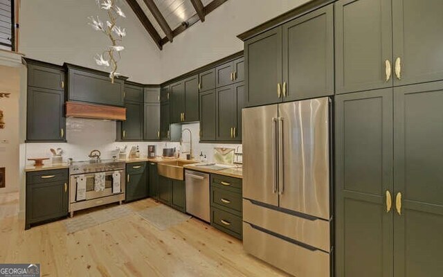 7670 Hiawassee Wilderness Trl, Hiawassee, GA 30546 - kitchen with appliances with stainless steel finishes, a sink, green cabinets, light wood-style floors, and high vaulted ceiling