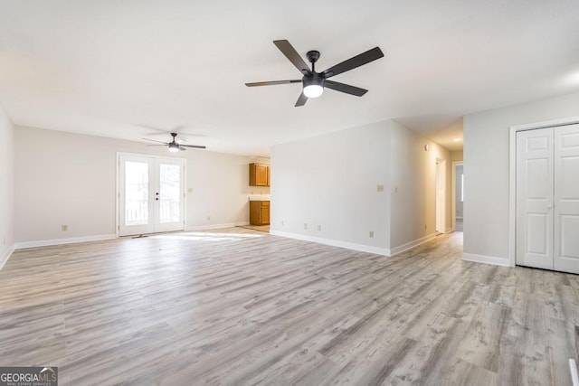 unfurnished living room with ceiling fan, light wood-type flooring, and french doors