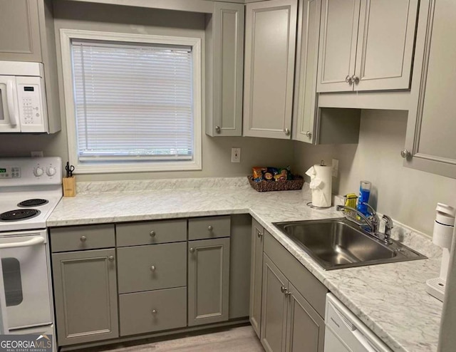 kitchen with gray cabinets, sink, and white appliances