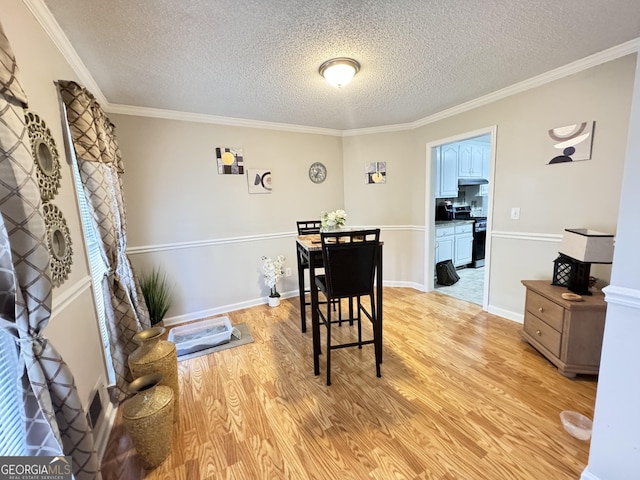 dining space featuring a textured ceiling, light hardwood / wood-style flooring, and ornamental molding