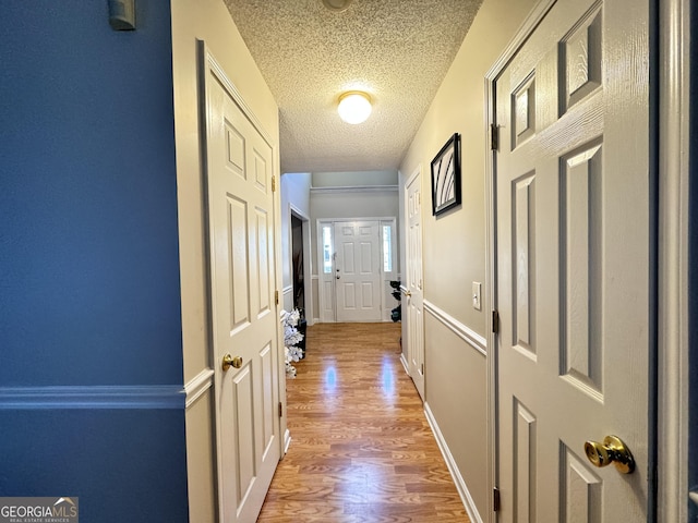 corridor featuring hardwood / wood-style floors and a textured ceiling