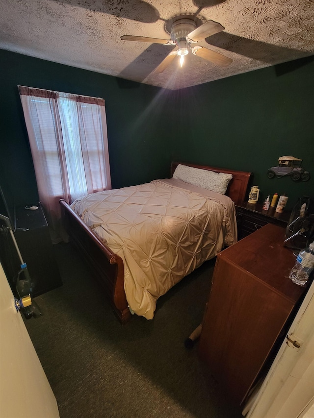 carpeted bedroom featuring ceiling fan and a textured ceiling