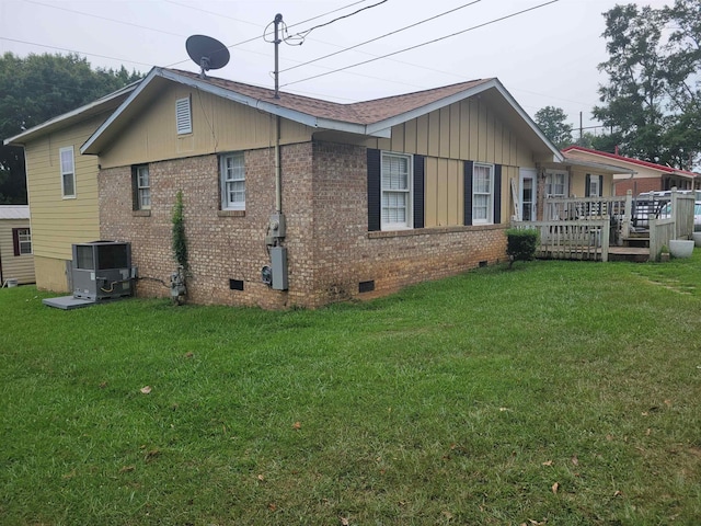 view of side of property with cooling unit, a lawn, and a deck