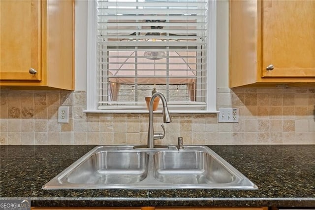 room details featuring dark stone countertops, sink, and tasteful backsplash