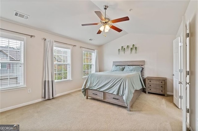 bedroom with ceiling fan, multiple windows, light carpet, and lofted ceiling