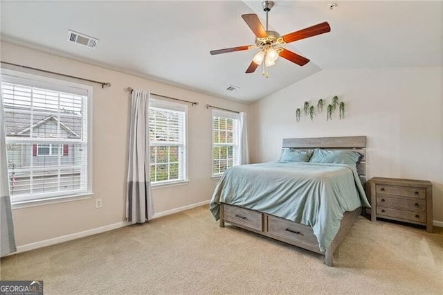 carpeted bedroom featuring multiple windows, vaulted ceiling, and ceiling fan