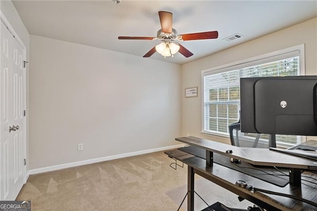 carpeted office space featuring ceiling fan