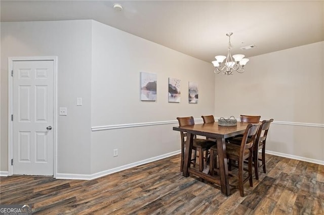 dining room with dark hardwood / wood-style floors and a chandelier