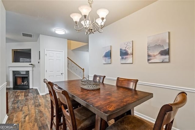 dining space featuring dark hardwood / wood-style flooring and a chandelier