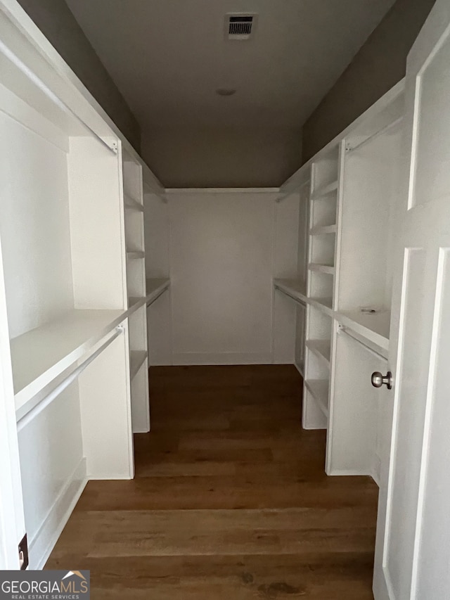 walk in closet with dark wood-type flooring