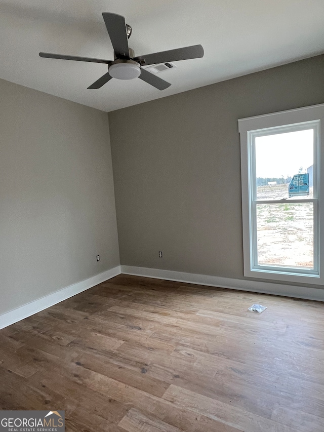 spare room with light wood-type flooring and ceiling fan