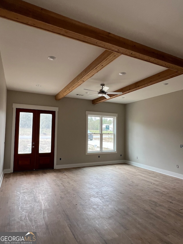 spare room featuring french doors, light hardwood / wood-style flooring, beamed ceiling, and ceiling fan