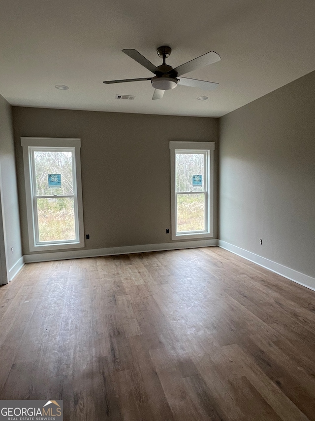 unfurnished room featuring light hardwood / wood-style floors, ceiling fan, and plenty of natural light