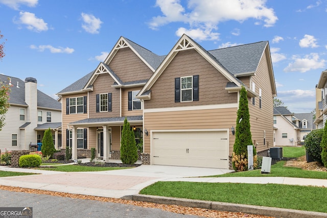 craftsman-style house with central air condition unit and a garage