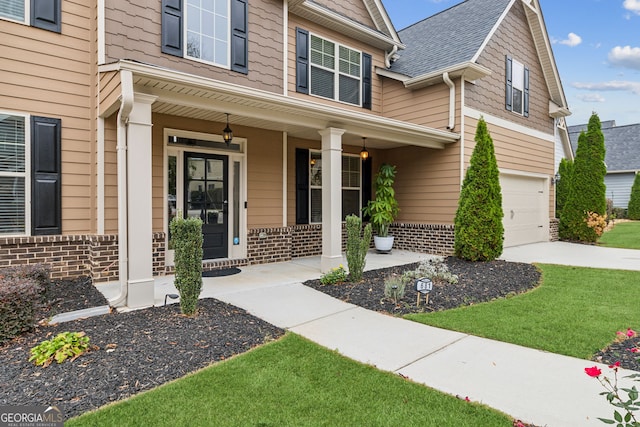 view of exterior entry with a garage and covered porch