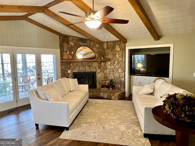 living room featuring french doors, ceiling fan, a fireplace, hardwood / wood-style floors, and vaulted ceiling with beams