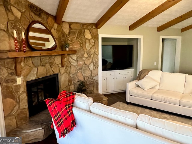 living room with beam ceiling, a stone fireplace, and hardwood / wood-style floors