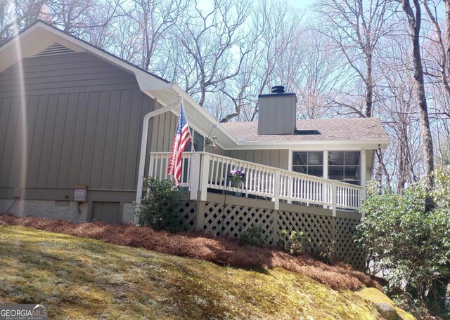 back of house with a lawn and a deck