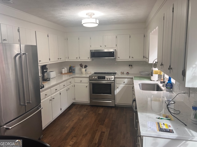 kitchen featuring white cabinetry, sink, dark hardwood / wood-style flooring, a textured ceiling, and appliances with stainless steel finishes