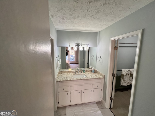 bathroom with vanity, a textured ceiling, and tile patterned floors